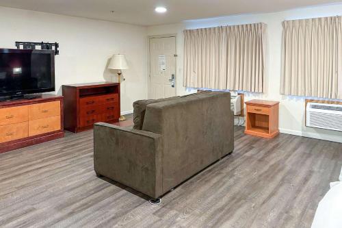 a living room with a couch and a television at Econo Lodge Edmonds North Seattle in Edmonds