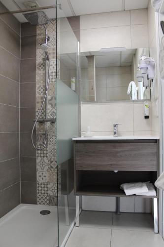 uma casa de banho com um chuveiro e um lavatório. em Logis Hôtel Auberge de l'Allagnonette em Saint-Poncy