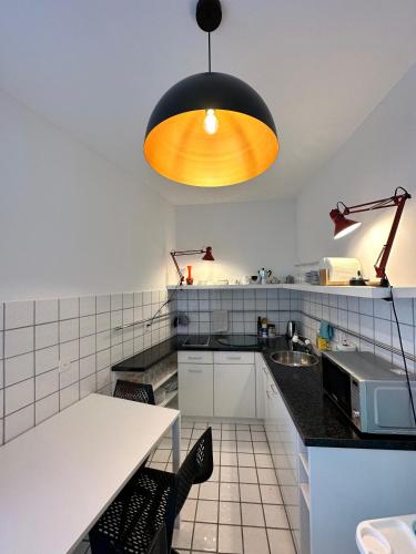 a kitchen with a table and a light fixture at Appartamento Ascona Vista Lago in Ascona