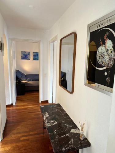 a room with a table and a mirror on a wall at Appartamento Ascona Vista Lago in Ascona