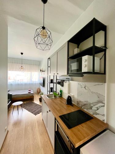 a kitchen with a counter top and a living room at Savi Apartment 4 in Pärnu
