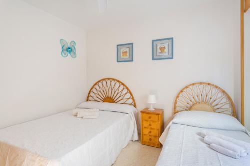 ein Schlafzimmer mit 2 Betten und eine Kommode mit einem Nachttisch in der Unterkunft Jardín X in Gandía