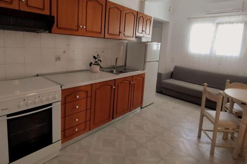a kitchen with wooden cabinets and a table and a couch at Center of Parga-John's House in Parga