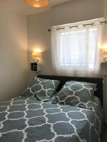 une chambre avec un lit et une fenêtre dans l'établissement Le Poseidon, à Saint-Raphaël