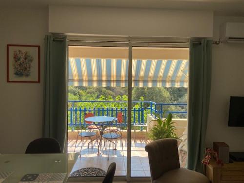 - un salon avec une porte en verre donnant sur une terrasse dans l'établissement Le Poseidon, à Saint-Raphaël