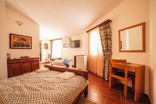 a bedroom with a bed and a desk and a table at Guest house Šebelj in Budva