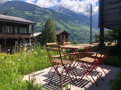 a table and chairs on a patio with a view of mountains at Mon Raccard Cosy - 4 vallées in Bruson