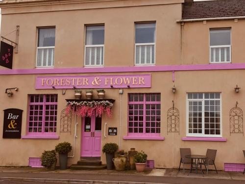 un edificio con una puerta rosa y una mesa en The Forester and Flower, en Bath