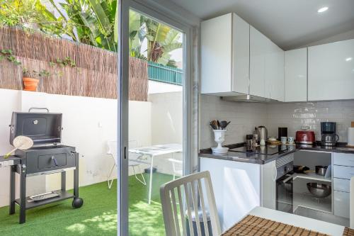 a kitchen with white cabinets and a stove at A Treat in Belém in Lisbon