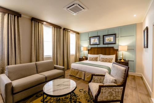 a hotel room with a bed and a couch and a table at Gold Reef City Theme Park Hotel in Johannesburg