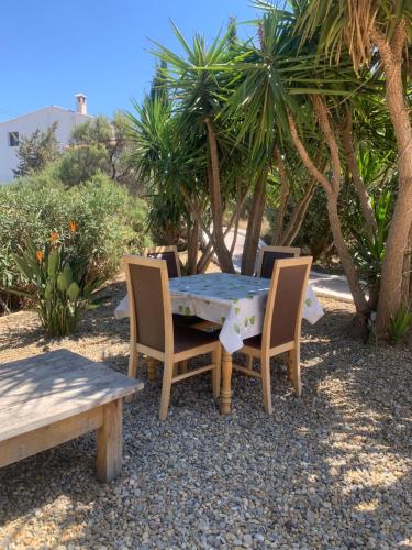 una mesa y sillas en un patio con palmeras en Lavender Lodge Almeria, en Arboleas
