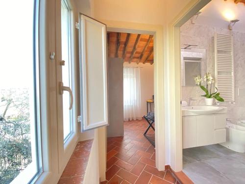 eine offene Tür zu einem Bad mit einem Waschbecken in der Unterkunft Relax&Business [Wi-fi, TV HD, Parcheggio gratuito] in Capannori