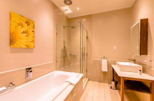 a bathroom with a tub and a sink at Gold Reef City Theme Park Hotel in Johannesburg