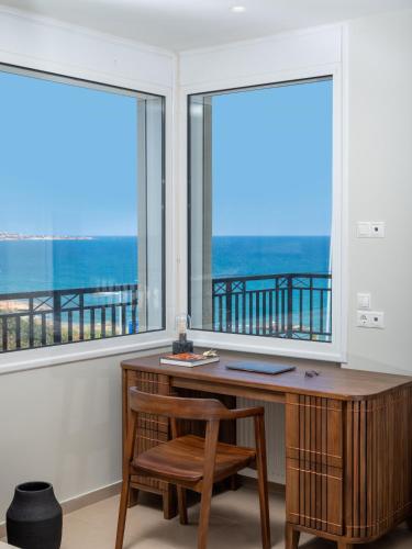 a desk and chair in a room with windows at Zuzu Riviera Living in Hersonissos