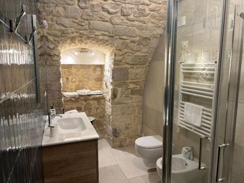 a stone bathroom with a sink and a toilet at Suite Duomo Trani 6 in Trani