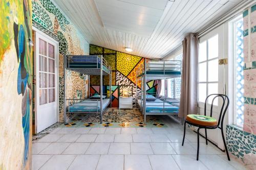 Cette chambre comprend des lits superposés et un mur orné de graffitis. dans l'établissement Gîte 1 à la Maison Mosaïc, à Gaillan-en-Médoc