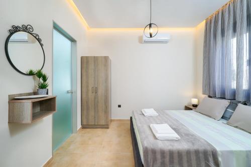a bedroom with a large bed and a mirror at Giorgio Suites in Asprovalta