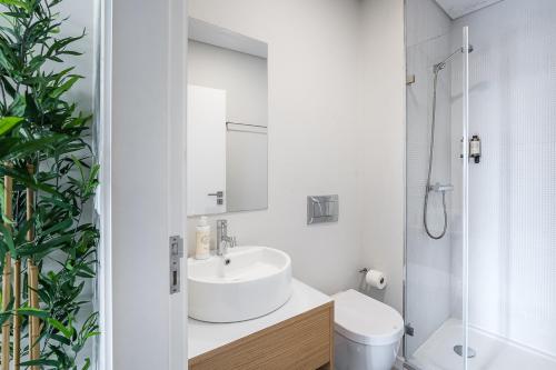 y baño blanco con lavabo y ducha. en General Torres Apartments en Vila Nova de Gaia