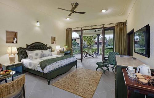 a bedroom with a bed and a living room at Vatsalya Vihar - A Luxury Pool Villas Resort in Udaipur