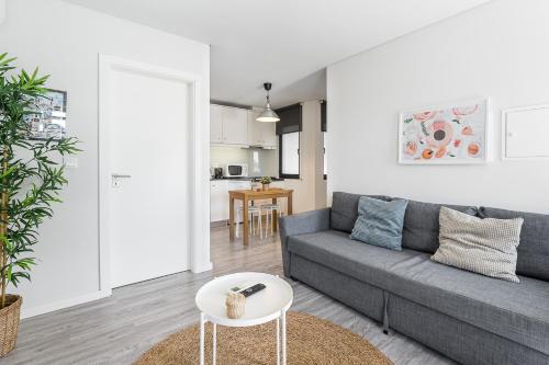 a living room with a gray couch and a table at General Torres Apartments by Lisbeyond in Vila Nova de Gaia