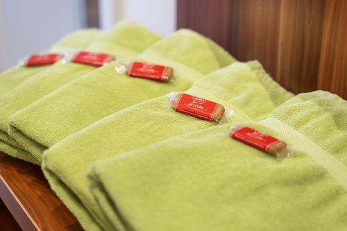 a row of green towels sitting on a bed at Apartment Felswelten in Bielatal