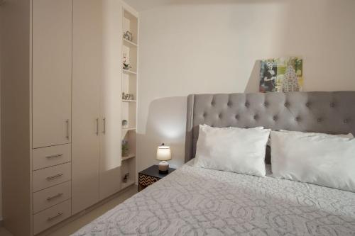 ein Schlafzimmer mit einem großen Bett mit einem grauen Kopfteil in der Unterkunft Downtown Guesthouse by Estia in Iraklio