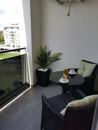 a room with a table and chairs and a balcony at Alex LUX in Banja Luka