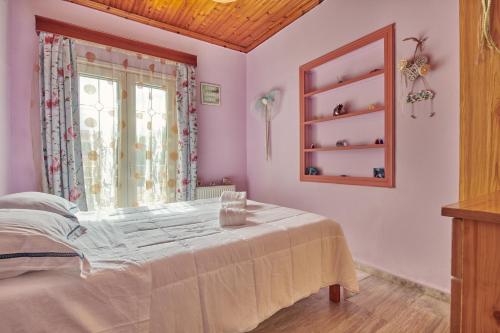 a bedroom with a bed and a window at Villa Roxa Montuoso in Agios Leon
