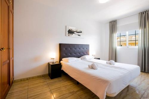 een slaapkamer met een groot bed met witte lakens bij Palm Mar Romantic Suite A11 in Palm-mar