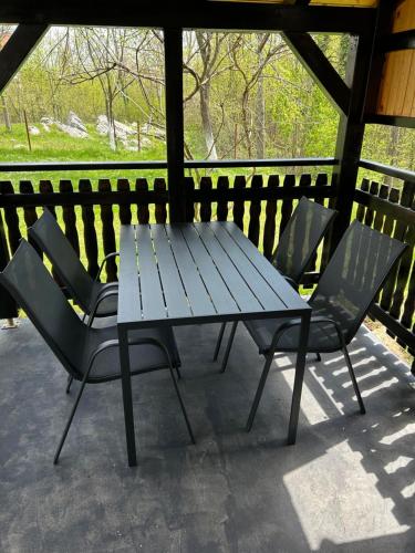 un tavolo da picnic e sedie su un portico di Apartman MAURO a Rakovica