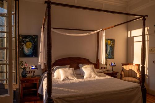 a bedroom with a canopy bed and a window at Hotel Pazo Libunca in Narón