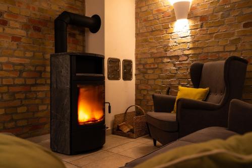 a wood burning stove in a living room with two chairs at Apartment Felswelten in Bielatal