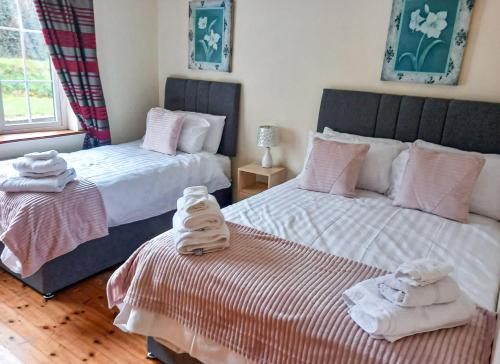 een slaapkamer met 2 bedden en handdoeken bij Shannons Gate in Killorglin