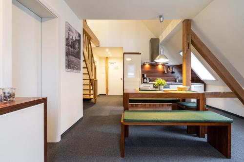 a living room with a staircase and a table and bench at Apartment Felswelten in Bielatal
