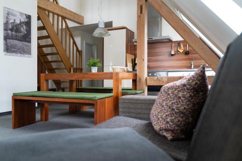 a living room with a couch and a table and stairs at Apartment Felswelten in Bielatal