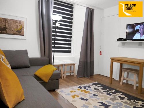 een woonkamer met een bank en een tv bij Blackie's Neuk - Ideal for Uni & West End in Dundee