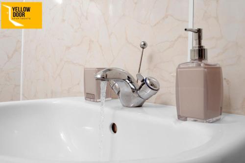 a bathroom sink with a soap dispenser next to a faucet at Blackie's Neuk - Ideal for Uni & West End in Dundee