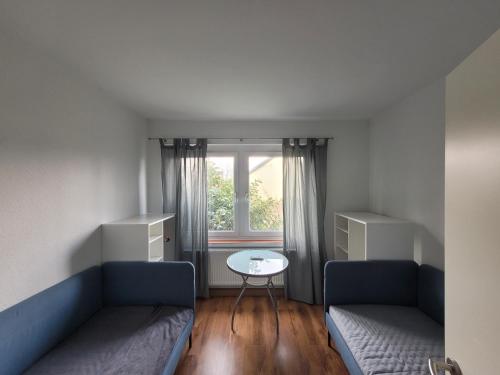 une chambre avec deux canapés, une table et une fenêtre dans l'établissement Monteurunterkunft Schützenhaus Leisnig, à Leisnig