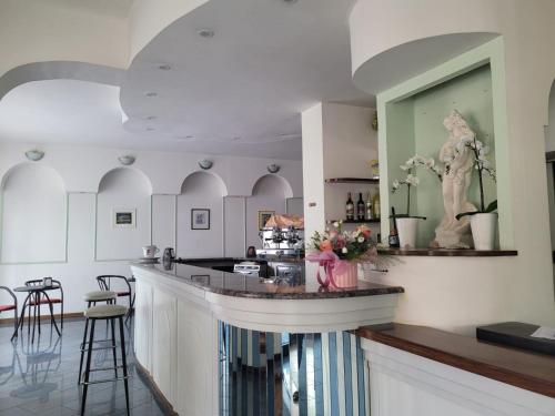 una cucina con un bar con una statua sopra di HOTEL VILLA ELISA a Rimini