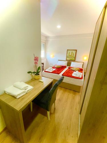 a bedroom with a bed and a desk and a table at Pansion Turudić in Međugorje