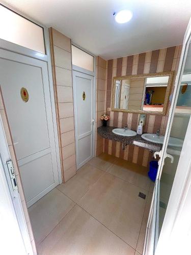 a bathroom with two sinks and two mirrors at Pansion Turudić in Međugorje