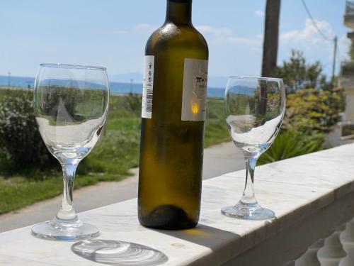 a bottle of wine and two wine glasses on a table at V&Z Apartment Seaview in Ofrínion