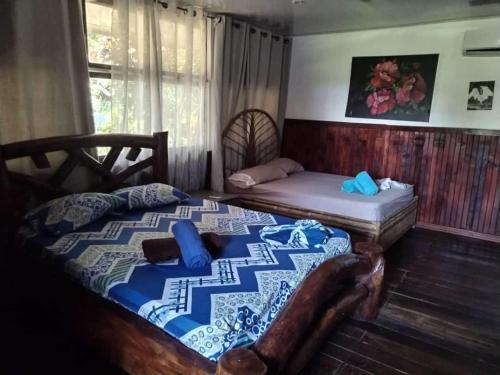 a bedroom with a bed and a bed and a couch at Natalias Beach House in Matapalo