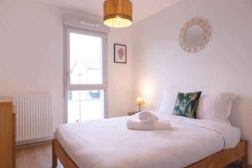 1 dormitorio con 1 cama blanca grande y ventana en Superbe appartement 2 chambres - parking gratuit, en Bourg-en-Bresse