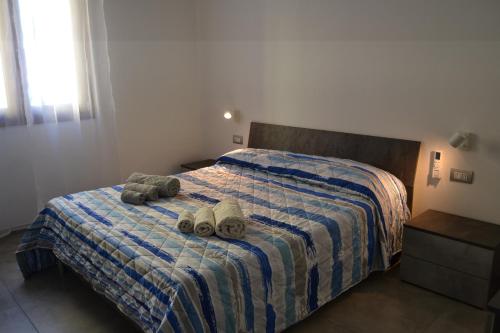 deux animaux farcis sont assis sur un lit dans l'établissement Becky's House casa vacanze, à Quartu SantʼElena