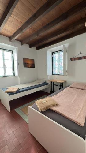 ein Schlafzimmer mit zwei Betten, einem Tisch und zwei Fenstern in der Unterkunft GetWet SurfCamp II in Costa da Caparica