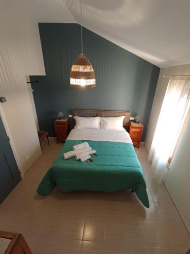 um quarto com uma cama com um cobertor verde em Affittacamere Locanda Ristoro Tanè em San Giovanni in Strada