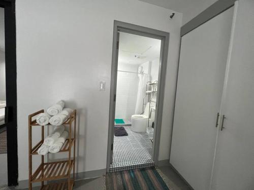 - un couloir avec une salle de bains pourvue d'un miroir et de toilettes dans l'établissement One Bedroom Condo Subic Bay, à Morong