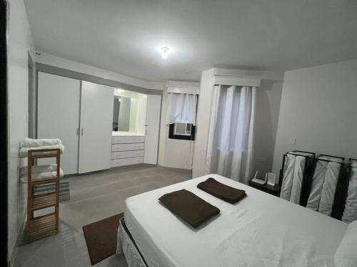 1 dormitorio con 1 cama blanca grande y 1 silla en One Bedroom Condo Subic Bay, en Morong