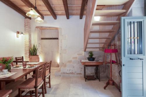 a dining room with a table and chairs and a staircase at DOMUS CLODIA, sensing Rethymno's Old Town! in Rethymno Town